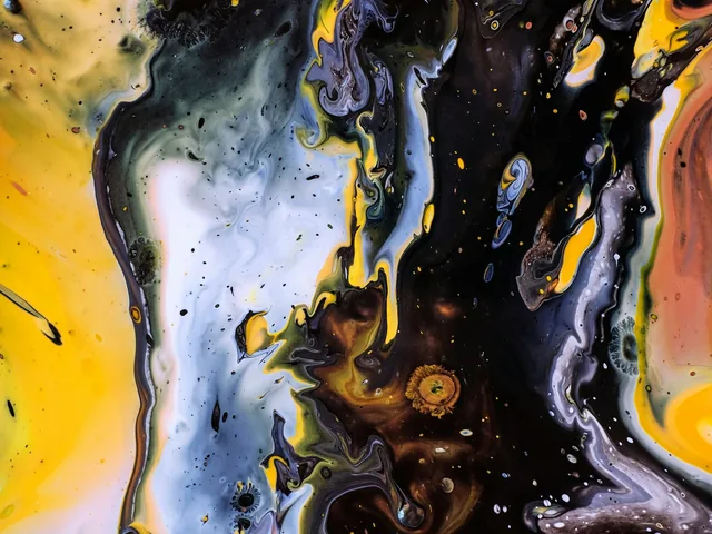 Yellow and dark paint flowing in an abstract composition